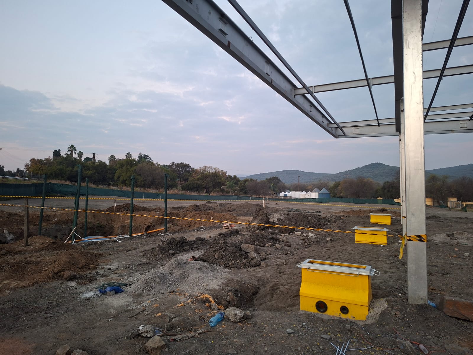 Fuel station canopy steel frame under construction at dusk