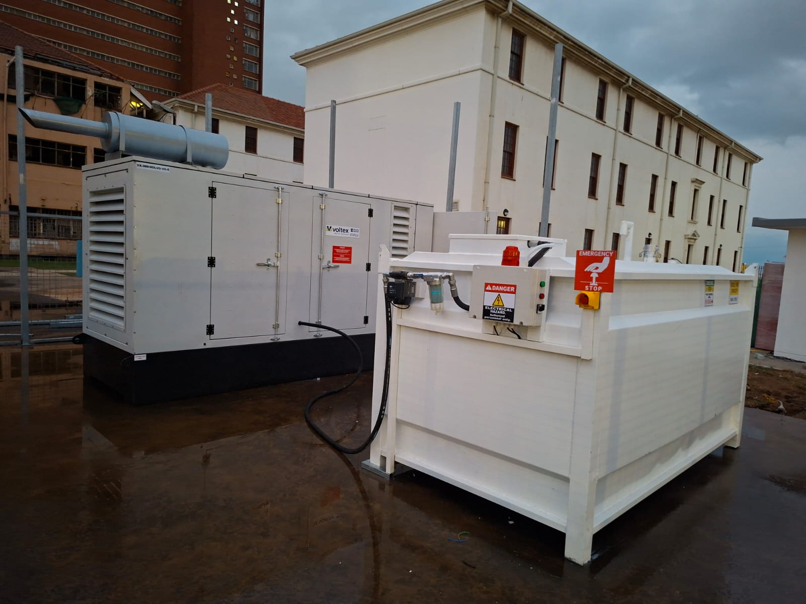 Aboveground fuel tank with pump, control panel and emergency stop beside a generator