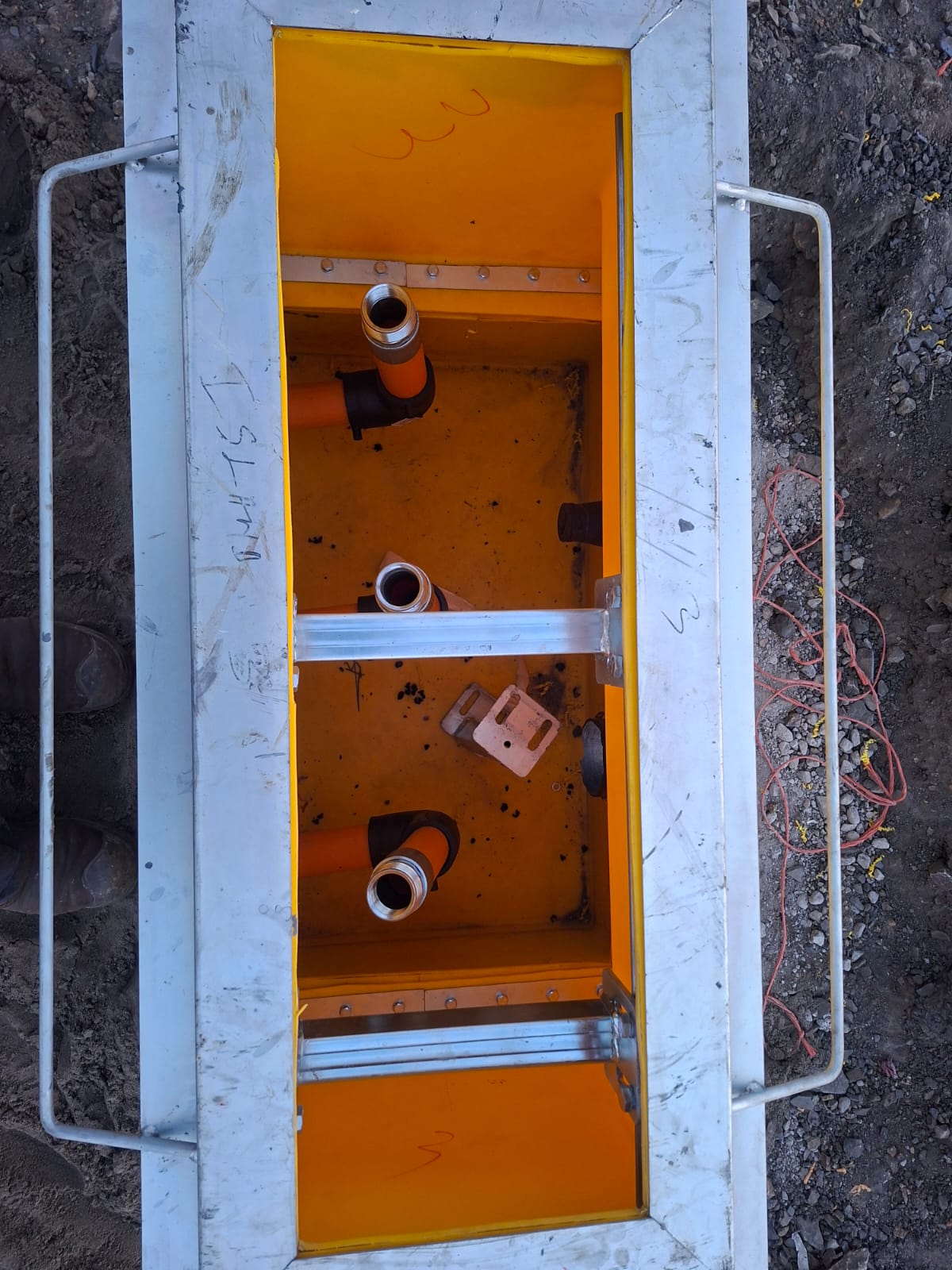 Inside a fuel station sump box showing pipe fittings inspection